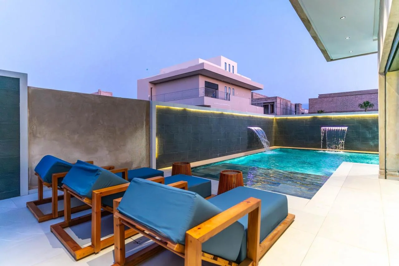 Transats au bord de la piscine en soirée